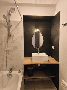 ein Badezimmer mit Waschbecken, Spiegel und Badewanne in der Unterkunft Studio Grand Balcon Montagne Ski et Randos in Luz-Saint-Sauveur