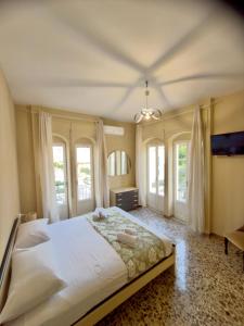 una camera da letto con un grande letto bianco e finestre di Sperlonga Center Home a Sperlonga