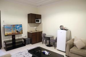 a living room with a couch and a tv and a table at بناية الســــــــــرايا للشقق المخدومة in Tabuk