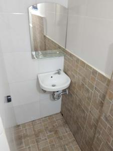 ein Badezimmer mit Waschbecken und Spiegel in der Unterkunft El Nido Cabugao Loudge in El Nido