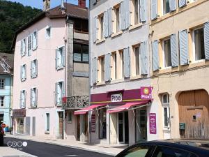 ein Gebäude mit einem rosa und lila Schild an einer Straße in der Unterkunft Studio 1 Classe 2, Fibre, Netflix in Moirans-en-Montagne