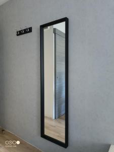 ein Spiegel mit schwarzem Rahmen an einer Wand in der Unterkunft Studio 1 Classe 2, Fibre, Netflix in Moirans-en-Montagne