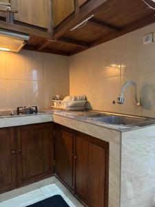 a kitchen with a sink and a counter top at Rumah Cahaya Syariah Peaceful Family Home in Rampal