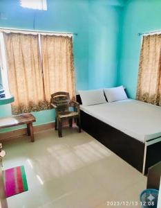 德奥加尔Alkapuri Guest House的有两张床和一把椅子的房间