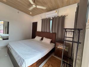a small bedroom with a bed and a ladder at Mosaic Hostel Varanasi in Varanasi
