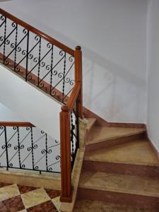 a staircase with wooden railings and a tile floor at Villa abdo in Asilah