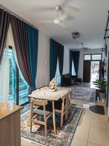 een eetkamer met een tafel en een woonkamer bij Aiman's Rose HomeStay in Teluk Panglima Garang