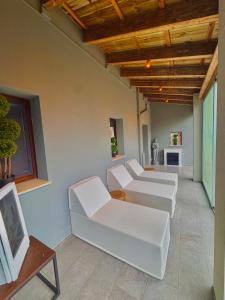 een woonkamer met witte meubels en een houten plafond bij La Siègià Resort spa in Massa Marittima