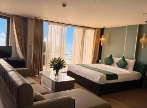 ein Hotelzimmer mit einem Bett und einer Couch in der Unterkunft Sapa Emerald Hotel in Sa Pa