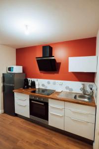 een keuken met een spoelbak en een zwarte koelkast bij Ancien Cloître rénové - Hyper centre - T2 de 50m2 in Mont-de-Marsan