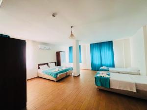 een grote kamer met 2 bedden en een houten vloer bij Şirin Apartrooms in Pamukkale