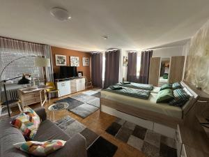 een woonkamer met een bed en een bank bij Haus - Sonneck in Schönwald