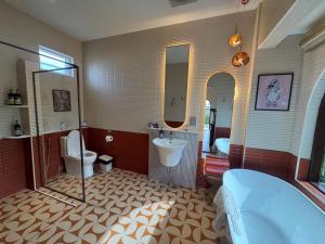 a bathroom with a tub and a toilet and a sink at Jc Pran บ้านพัก in Sam Roi Yot +68 photos
