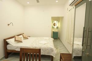 a small bedroom with a bed and a mirror at Mermaid Marari in Mararikulam +4 photos