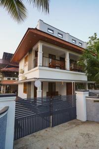 a house with a fence in front of it at Mermaid Marari in Mararikulam