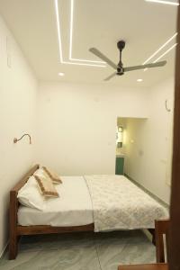 a bedroom with a bed with a ceiling fan at Mermaid Marari in Mararikulam