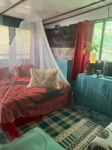 een slaapkamer met een bed met een klamboe bij Fare Te ava Fitii in Fitii