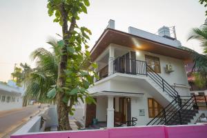 a white house with a tree in front of it at Mermaid Marari in Mararikulam