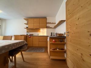 a small kitchen with wooden cabinets and a table at Suite Panorama in Valdisotto