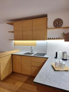 a kitchen with wooden cabinets and a sink at Suite Panorama in Valdisotto
