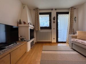a living room with a television and a couch at Suite Panorama in Valdisotto