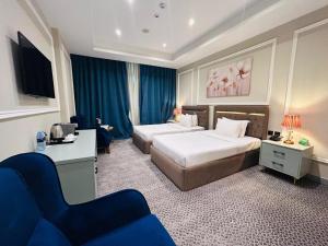 una camera d'albergo con due letti e un divano di Al Mansour Plaza Hotel a Doha Altre 50 foto