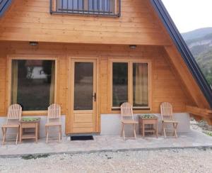 een groep stoelen en een tafel voor een cabine bij Vila Ivana in Sirogojno