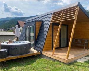 een klein huis met een grote jacuzzi op een terras bij Vila Ivana in Sirogojno
