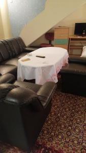 een woonkamer met een tafel en een leren bank bij Апартамент опера in Varna