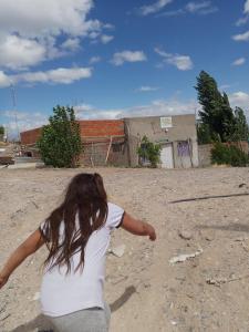 Een vrouw laat een vlieger op in de modder. bij La Posada in Neuquén