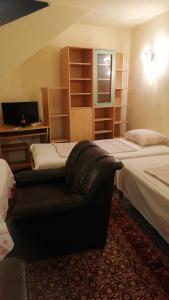 een slaapkamer met twee bedden en een bank erin bij Апартамент опера in Varna