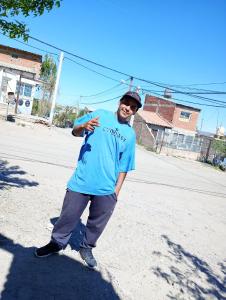 een man in een blauw shirt staat op straat bij La Posada in Neuquén