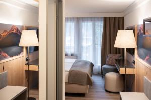 a hotel room with a bed and a desk at Hotel Grindelwalderhof in Grindelwald +52 photos
