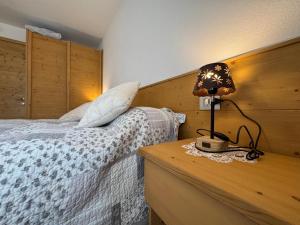 a bedroom with a bed and a lamp on a night stand at Suite Panorama in Valdisotto