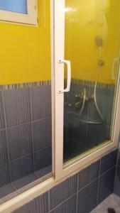 een badkamer met een douche met een glazen deur bij Апартамент опера in Varna