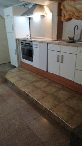 een keuken met witte kasten en een kookplaat oven bij Апартамент опера in Varna +11 foto's