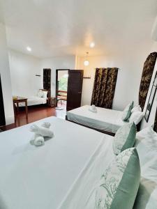 a hotel room with two beds and a living room at LUZVILLE Transient House - Port Barton in Itaytay