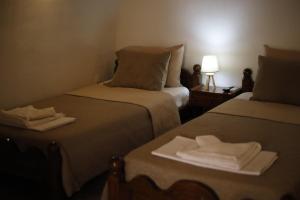 ein Hotelzimmer mit zwei Betten mit Handtüchern darauf in der Unterkunft SternesVillage, Middle Ground Floor in Stérnai