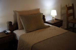 ein Schlafzimmer mit einem Bett mit einer Lampe und einem Bett mit einem sidx sidx sidx in der Unterkunft SternesVillage, Middle Ground Floor in Stérnai + 1 Foto