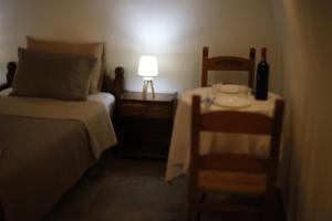 ein Schlafzimmer mit einem Bett und einem Tisch mit einer Lampe in der Unterkunft SternesVillage, Middle Ground Floor in Stérnai