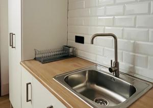 eine Küche mit einer Spüle aus Edelstahl und einer Theke in der Unterkunft Estudio Vandelvira in Baeza