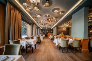 ein Esszimmer mit weißen Tischen und Stühlen in der Unterkunft Kongress Hotel Davos in Davos