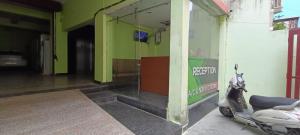 a scooter parked outside of a building with a green wall at Star hill in Rishīkesh