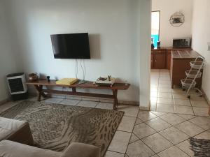 een woonkamer met een tafel en een tv bij Sobrado sustentavel e ecológico alugo casa de hóspedes setor campinas in Goiânia
