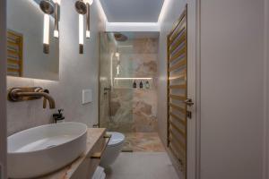 une salle de bains avec lavabo, toilettes et douche dans l'établissement Mountain Pine Luxury Suites, à Flórina 42 autres photos