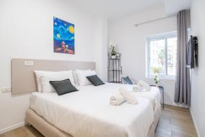 zwei weiße Betten in einem weißen Schlafzimmer mit Fenster in der Unterkunft Da Vinci in Jerusalem + 4 Fotos