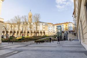 a city street with buildings and a clock tower at Go-Vi Gozar en Vitoria in Vitoria-Gasteiz