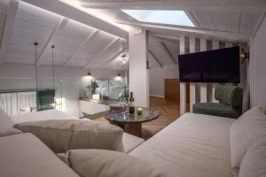 un salon avec un canapé et une télévision dans l'établissement Mountain Pine Luxury Suites, à Flórina