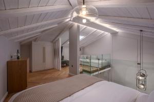 une chambre avec un lit et un plafond blanc dans l'établissement Mountain Pine Luxury Suites, à Flórina