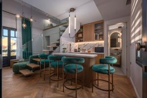 une cuisine avec un bar avec des tabourets verts dans l'établissement Mountain Pine Luxury Suites, à Flórina